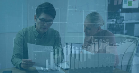 Reviewing Asian man and woman analyzing data at office table with laptop and holographic chart....