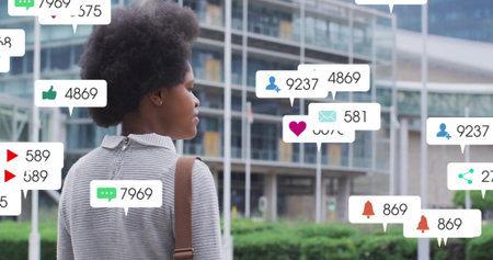Image of social media notification icons overlaying person standing outdoors. Technology, digital,...