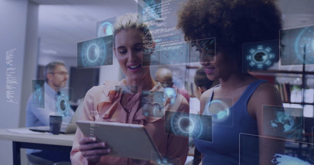 Examining female colleagues discussing tablet in open office, with floating holographic charts. Collaboration, innovation, technology, modernity, teamwork, digital, progressの写真素材