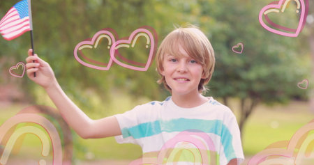 Boy holding American flag high in sunny garden, with pastel rainbow heart graphics. Child,...