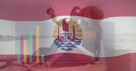 Pointing at smartphone screen, couple in swimwear sitting on beach, bar chart, flag overlay. Tropical, leisure, relaxation, exploration, communication, scenic, vibrantの写真素材