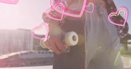 Holding skateboard by deck woman wearing red shirt with bracelets at skate park, heart overlay....