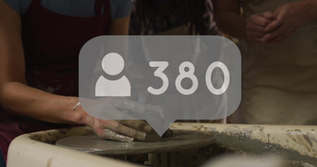 Molding clay vessel with adult man's wet hands at pottery workshop, with user icon showing 380. Ceramics, craftsmanship, artisan, studio, education, creativity, manualの写真素材