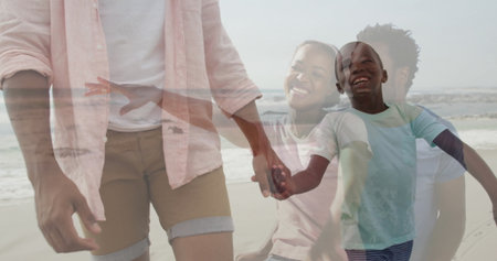 Walking father and son in pink and blue tees hand-in-hand along sandy beach, gentle waves lapping....