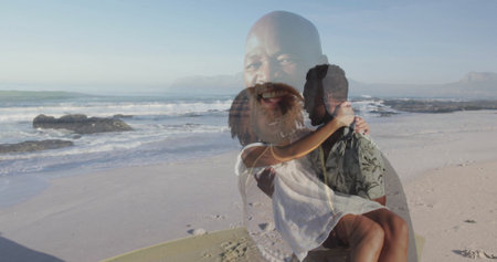 Embracing romantic couple sitting on sandy beach, with translucent smiling portrait overlay....