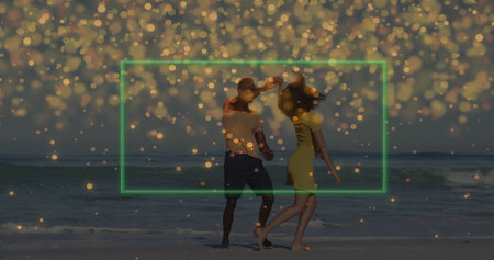Dancing barefoot couple holding hands at beach edge with rolling ocean waves, golden bokeh overlay....