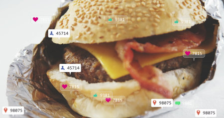 Bacon cheeseburger sitting in sesame-seed bun foil wrap on studio surface, with social media icons. Fast food, gourmet, vibrant, appetizing, casual, branding, social mediaの写真素材