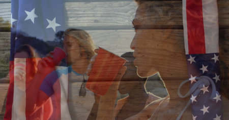 Drinking friends holding red plastic cups at lakeshore during sunset, American flag overlay....