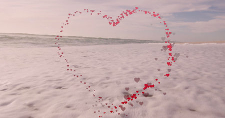 Clustering small red and gray heart shapes forming heart outline at shoreline, with ocean waves. Romantic, coastal, minimalist, love, soothing, nature, symbolicの写真素材