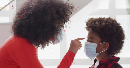 Leaning masked woman in red sweater pointing at boy's forehead at grid windows, with surgical masks. Family, connection, warmth, caring, affection, bright, modernの写真素材