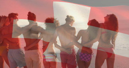 Hugging friends wearing swimwear facing sunset horizon on sandy shore, with Swiss flag overlay. Family, unity, celebration, leisure, relaxation, voyage, adventureの写真素材
