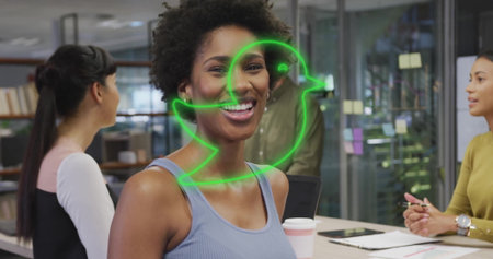 Talking coworker in gray tank top presenting ideas around table in modern office, with laptop. Collaboration, teamwork, brainstorming, innovation, modern, professional, officeの写真素材