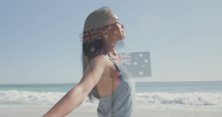 Standing woman stretching arms toward sun on sandy beach, wearing sportswear, copy space. Meditation, wellness, serenity, leisure, outdoor, vitality, naturalの写真素材
