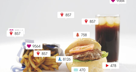 Displaying cheeseburger with lettuce and tomato by fries and cola on table, with notification icons....