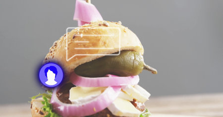 Showing stacked sandwich on wooden table with sesame bun, pickled onions, pepper spear and skewer. Gourmet, culinary, minimalist, rustic, fresh, vibrant, appetizingの写真素材