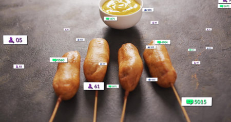 Showing four skewered sausages on slate counter, with white bowl of yellow sauce and digital icons. Food, snack, appetizer, modern, graphic, digital, social mediaの写真素材