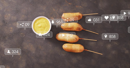 Displaying four corn dogs on wooden skewers on dark stone tabletop, with digital overlay icons. Snack, casual dining, rustic, vibrant, digital marketing, social media, appetizerの写真素材