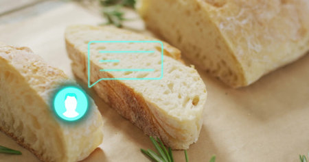 Displaying crusty bread slice on parchment on wooden countertop, with rosemary and turquoise icon....