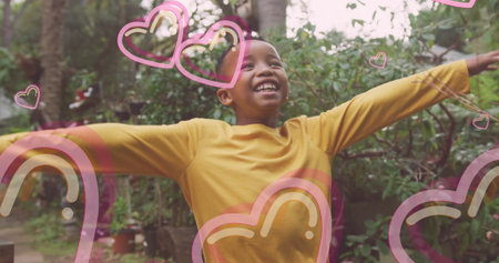 Smiling boy raising arms and lifting chin in backyard garden, with heart and rainbow overlays. Joyful, outdoor, nature, vibrant, innocence, positivity, leisureの写真素材