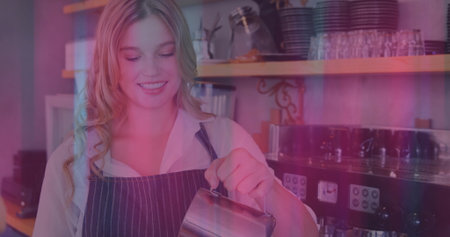 Steaming milk barista in white shirt and apron in cafe, with stainless pitcher, espresso machine....