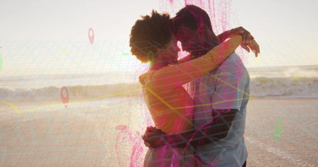 Hugging couple wearing beachwear at waters edge on beach during sunset, with digital map overlay. Romantic, connection, adventure, exploration, destination, leisure, sceneryの写真素材