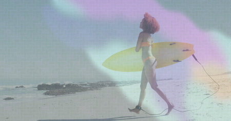 Walking woman carrying yellow surfboard on sandy shore, orange bikini with ankle leash, copy space....