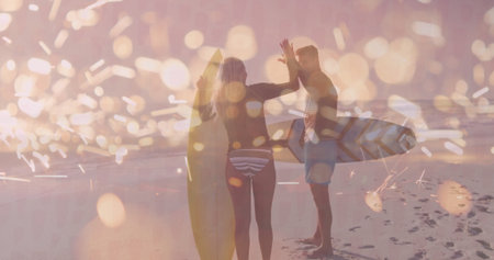 High-fiving surfers wearing swimwear holding surfboards on sunset beach, with footprints in sand. Vacation, adventure, coastline, serenity, leisure, vibrant, camaraderieの写真素材