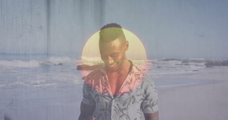 Man in tropical-print shirt holding smartphone on sandy beach shoreline, with pastel sun graphic....