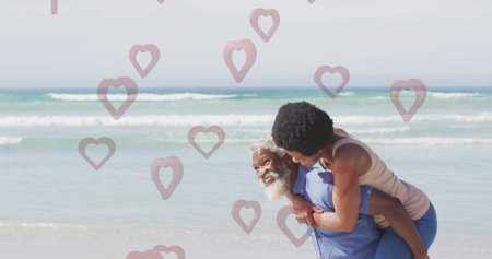 Giving man in blue shirt carrying woman in jeans on piggyback at sandy beach, copy space. Couple, beach, leisure, relaxation, happiness, outdoors, scenicの写真素材