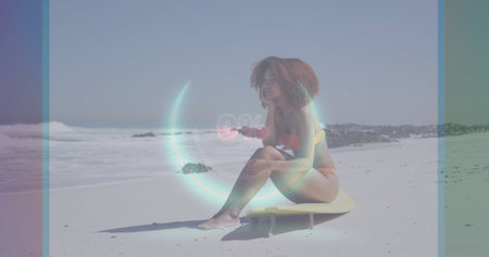 Sitting woman wearing orange bikini gazing at ocean on yellow surfboard on sand, 0% digital overlay. Beach, coastal, leisure, relaxation, modern, vibrant, adventureの写真素材