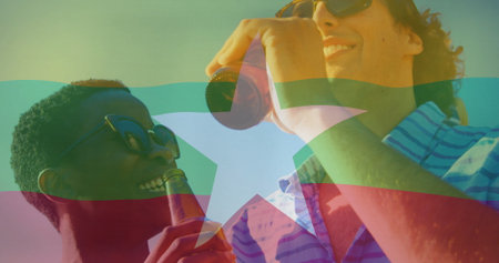 Smiling two friends wearing striped shirt sipping beer under clear sky with bottles and sunglasses. Casual, friendship, leisure, vibrant, outdoor, relaxation, lifestyleの写真素材