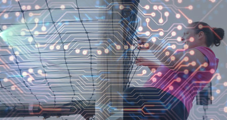 Climbing woman wearing pink sportswear on cargo net in gym, circuit board overlay, copy space....