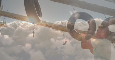 Climbing athlete wearing workout gear pulling through tire on chains at obstacle course, copy space. Adventure, fitness, endurance, outdoor, sport, strength, challengeの写真素材