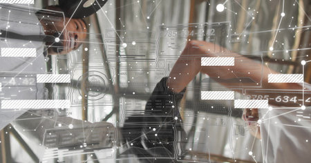 Colleagues exchanging handshake at office desk, with glass partitions and digital network overlay....