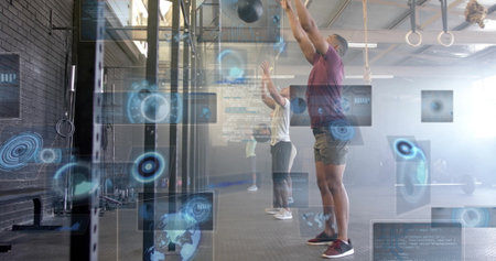 Hoisting med balls overhead, group in sportswear training at gym with pull-up rig, UI overlays....