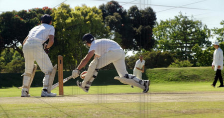 Diving batsman in white kit stretching bat toward crease on cricket pitch, with wooden stumps. Sports, competition, athleticism, motion, outdoor, intensity, teamの写真素材