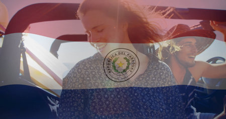 Driving friends wearing straw hat in red convertible on sunlit highway, with Paraguay flag overlay. Adventure, freedom, leisure, vibrant, lifestyle, outdoor, youthfulの写真素材