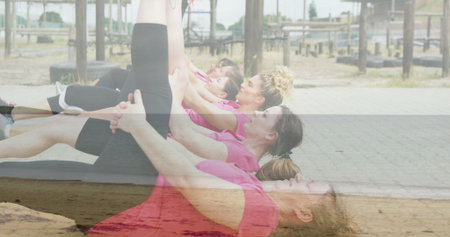 Performing leg raises six women wearing pink tops on mats at outdoor park with pull-up bars....