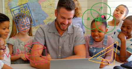 Teaching man in gray shirt guiding children around laptop in classroom, with map and math doodles....