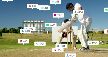Swinging batsman holding cricket bat facing floating social media icons on grassy field, copy space....