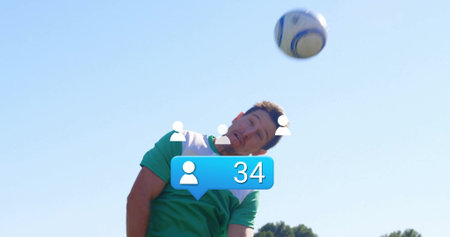 Soccer player wearing jersey jumping and heading ball on field, with overlay icons and bubble....