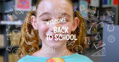 Schoolgirl in teal top holding apple in school library with doodles, WELCOME BACK TO SCHOOL overlay. Education, learning, childhood, literacy, creativity, classroom, motivationの写真素材