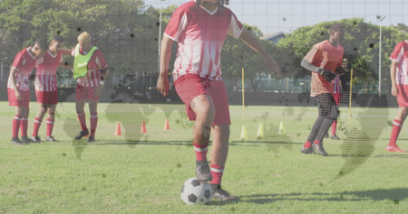 Central soccer player controlling ball in grass training pitch, with cones and bibs. Athletes, teamwork, sports, fitness, outdoor, competition, agilityの写真素材