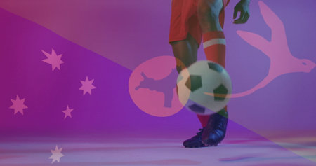 Balancing Black soccer player's legs in red kit controlling ball in studio, with Aussie stars, kiwi. Athletic, dynamic, vibrant, competitive, modern, energetic, performanceの写真素材