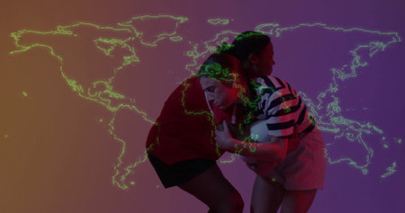 Two athletes grappling rugby ball wearing athletic shirts in studio with neon world map projection. Athletes, strength, teamwork, fitness, dynamic, modern, competitionの写真素材