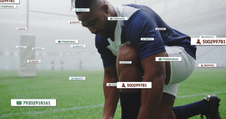 Kneeling athlete wearing cleats tying laces on misty field, with goalposts and tracking tags. Athlete, sports, performance, foggy, outdoor, competition, athleticismの写真素材