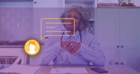 Senior medical professional consulting virtually in home kitchen, with stethoscope and chat icons. Healthcare, telemedicine, professional, modern, communication, homeoffice, wellnessの写真素材