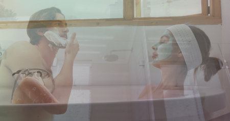 Shirtless man and woman wearing spa headband and facial mask grooming in bathtub, with shaving foam. Spa, relaxation, skincare, wellness, intimate, cozy, naturalの写真素材