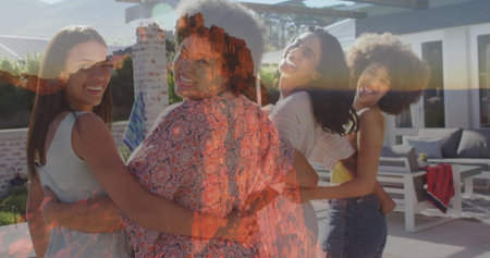 Smiling four friends linking arms on backyard patio, with white lounge chairs, red towel and plants. Friendly, camaraderie, outdoor, leisure, modern, vibrant, socialの写真素材