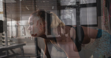 Fitness partners holding squat and performing ring push-ups in fitness studio, with gymnastic rings. Strength, teamwork, gym, exercise, wellness, motivation, trainingの写真素材
